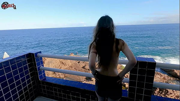 Mel strips on the balcony in front of people
