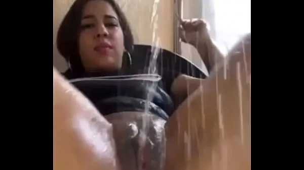 Latina sacando chorros al lado de la ventana como fuente